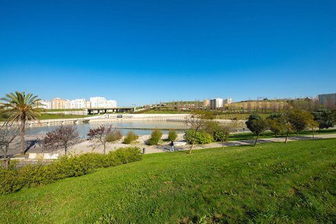 Relvado e lago num parque urbano de Lisboa